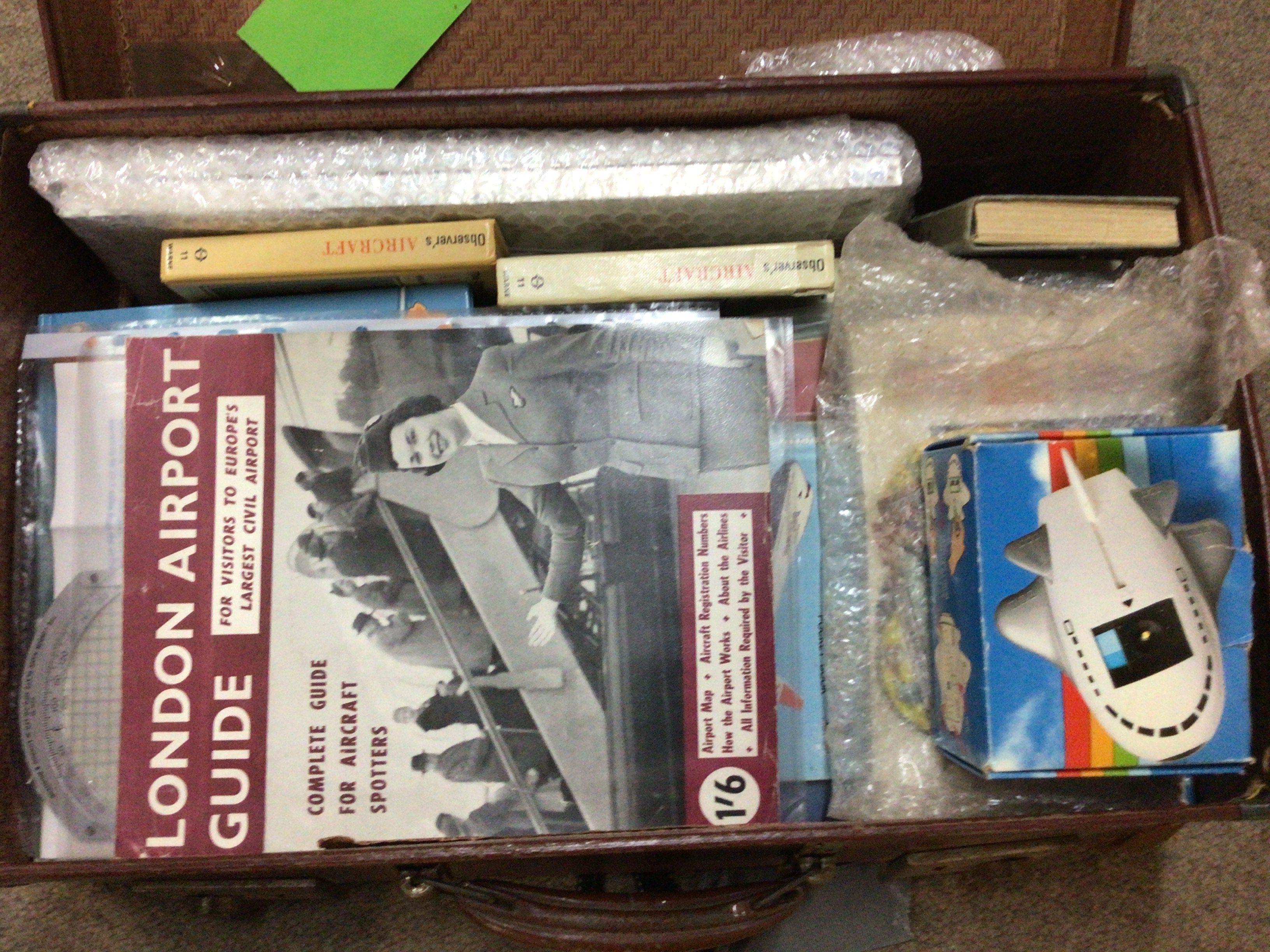 A vintage suite case containing Aircraft memorabilia including early promotional civil aviation brochures coin collection and other related ephemera.