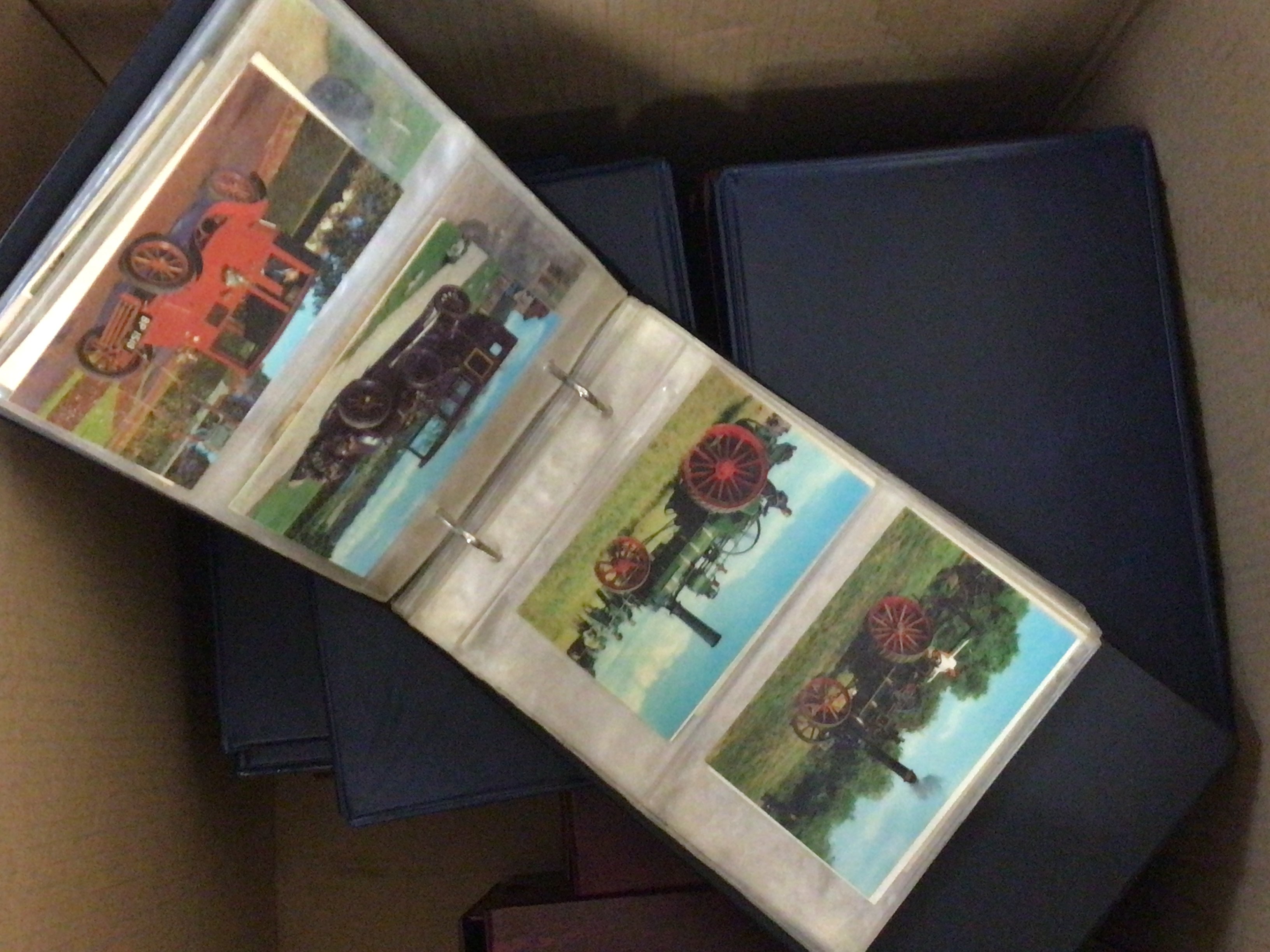 A box containing a collection of albums of postcards and cigarette cards.