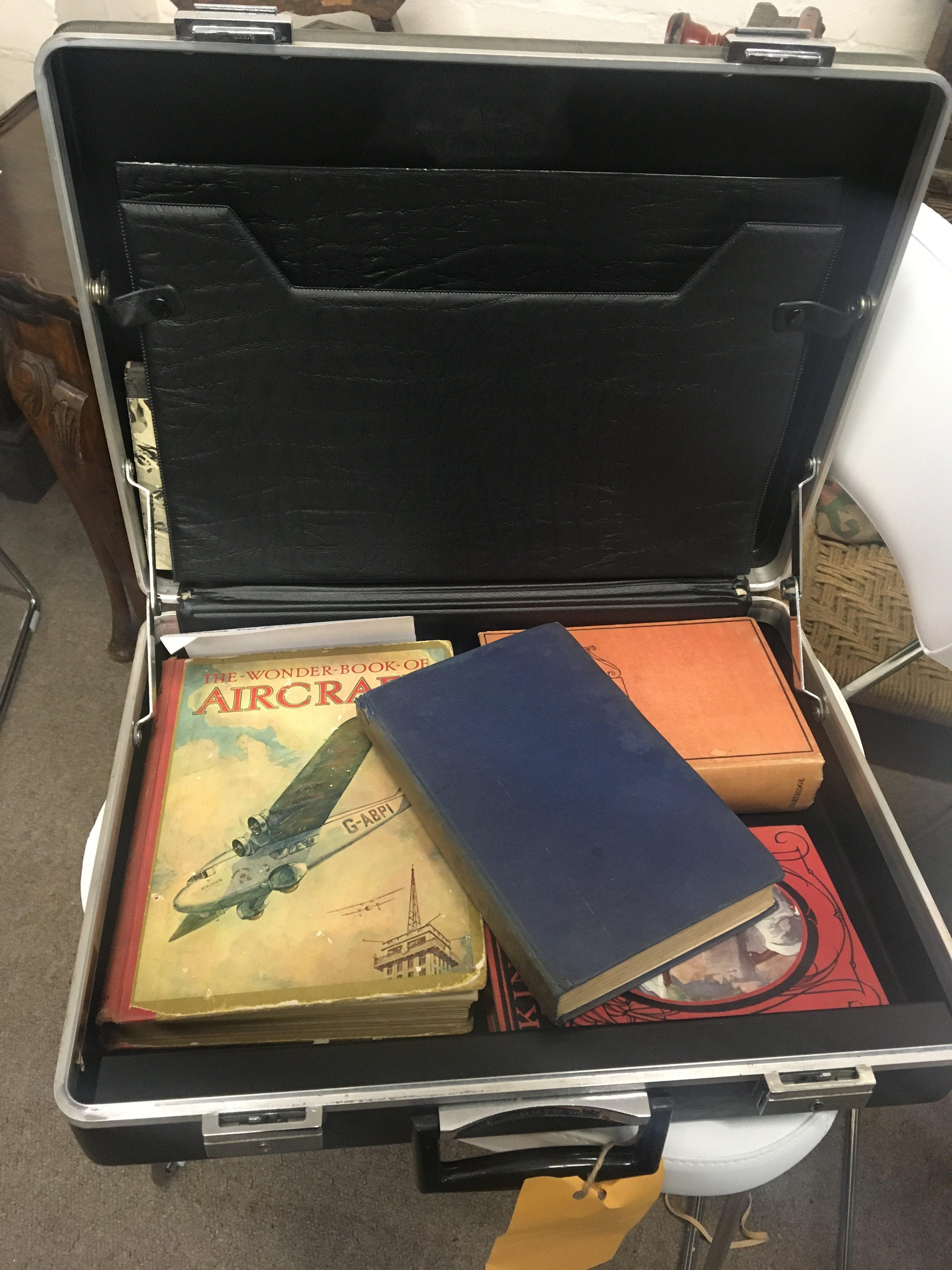 A collection of boxes of books mainly Civil Aviation books VHS videos and DVD and a briefcase containing books.