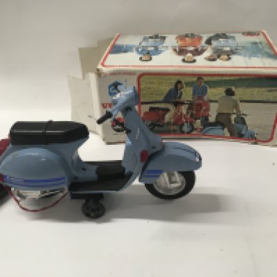 A boxed Piaggio Vespa scooter battery operated. Box in poor condition.