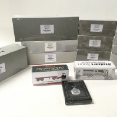 A collection of 12 boxed diecast model commercial vehicles by Atlas all themed Eddie Stobart. Mainly sealed with original plastic film. Includes sealed Eddie Stobart pocket watch.