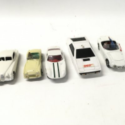 A collection of 5 loose diecast model cars by Dinky and Corgi includes 2 007 themed cars.