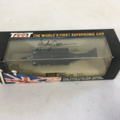 A boxed model of Thrust the worlds first supersonic car. This model has been signed by Andy Green the driver of Thrust.