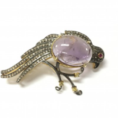 A large silver gilt bird of paradise brooch which can double as a pendant set with a large oval cabochon amethyst rose and round cut diamonds and a ruby. Fitted with a hinged pin and loop. Amethyst 12.30ct and diamonds 1.17ct. Approximately 5.5cm wide