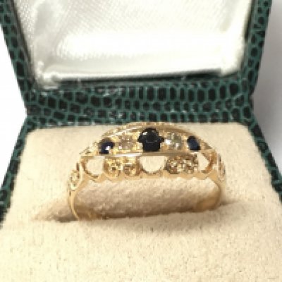 An 18ct yellow gold sapphire and diamond ring with carved detailing. Circa 1915. Sapphire 0.10ct and diamonds 0.04ct Approx. Size L