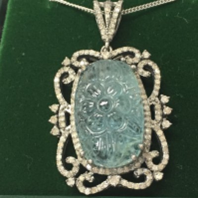 A silver pendant set with a large carved aquamarine and diamonds on a silver chain. Aquamarine 12.43ct diamonds 1.04ct Postage B