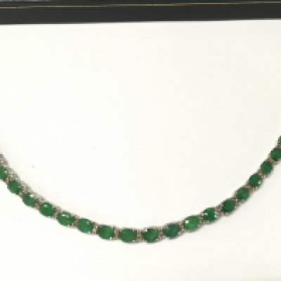 An 18ct white gold oval emerald and diamond line bracelet with an open box clasp and double safety catch. Emeralds 7.88ct and diamonds 0.55ct. Approx 18cm long. Postage B