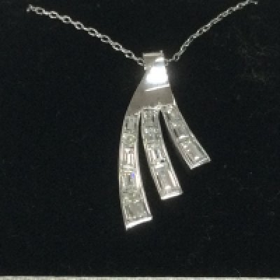 A modern design 18ct white gold pendant set with tapered baguette cut diamonds, approx 1ct. Shipping category A.