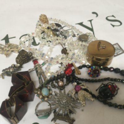 A collection of costume jewellery including a Beatle brooch and other brooches rings and oddments.