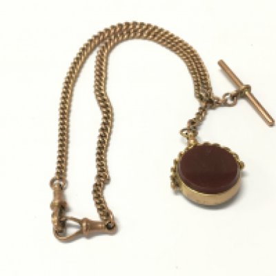 A 9ct gold graduating Albert chain with a spinning fob and T-bar attached.