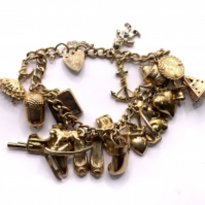 A heavy 9ct gold multi charm bracelet. 34.04gs (A)