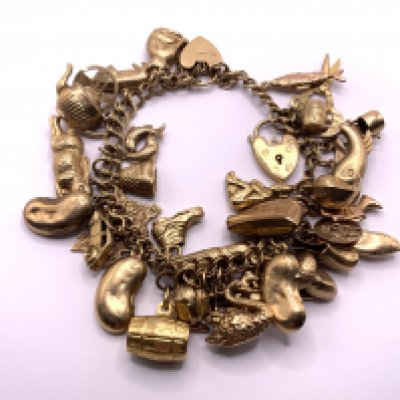 A heavy 9ct gold multi charm bracelet. 46.3gs (A)