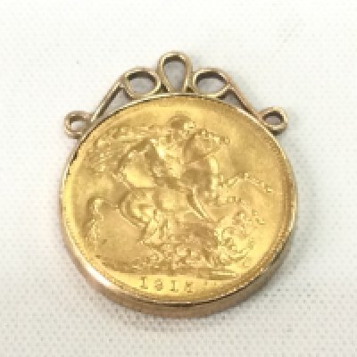 A 1915 gold sovereign in a gold mount, approx 9.7g. Shipping category A.