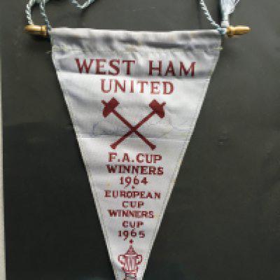 Bobby Moore Signed 1965 ECWC Football Pennant: Small West Ham pennant stating 1964 FA Cup and 1965 ECWC winners hand signed in biro lightly by Bobby Moore. C/W programme and ticket for 1965 final. Look great framed.