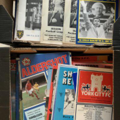 Wimbledon Football Programmes: 42 from the first season of 77/78 with a further 35 from the next season. C/W Dons Outlook and Gravevine Fanzines. There are many from 79/80 and throughout the 80s with some complete. Scrapbook comes with privately taken photos from the 1988 FA Cup Final celebrations. (2 boxes)