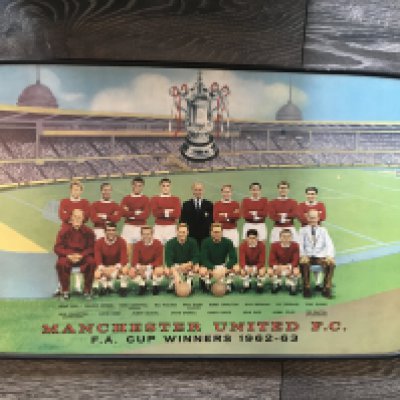 1963 Manchester United FA Cup Winners Coffee Table: Stunning original 60 years old table which pictures the Manchester United team and in the background is Wembley and the fa cup. Players have printed names underneath and the words FA Cup Winners 1962-63. Colourful 2 feet x 15 inch table with 4 legs that unscrew making it possible to send. Stunning condition. Probably unused.