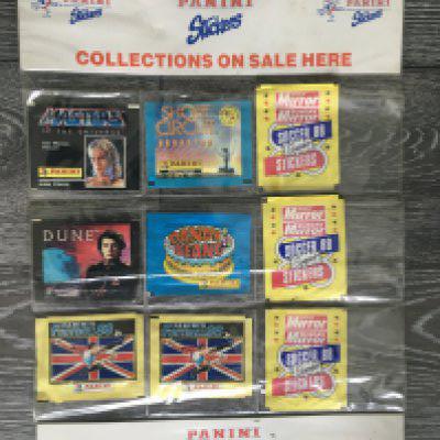 Panini Stickers Shop Display Card Holder: Direct from shop with original hanging string p. Holds 9 packs and still has 9 unopened packs in which consist of Masters of the Universe, Dune, Short Circuit, Dandy Beano plus 2 Football 88 and 3 non Panini Daily Mirror Soccer 88 packs. Rare item.
