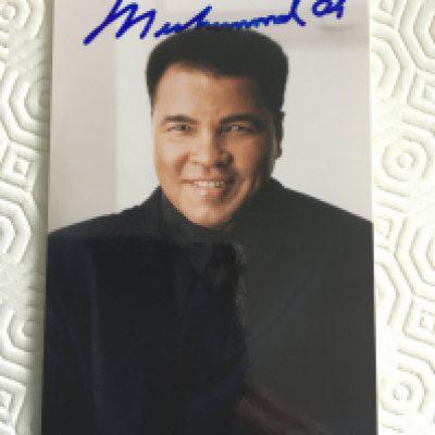 Muhammad Ali Signed Boxing Photo: Postcard size photo of Ali sent to fan. Back has a printed personal message. Signed to front undedicated clearly in blue marker pen. C/W unsigned autobiography of him. (2)
