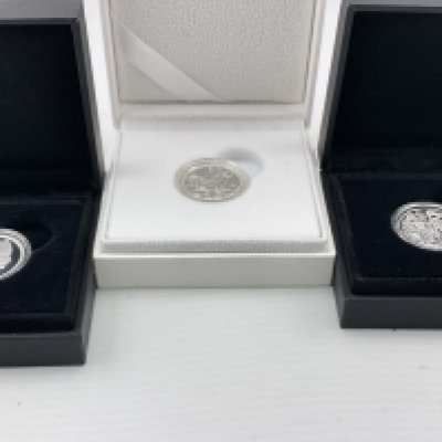 A proof silver sovereign and two further silver coins. Postage category A.