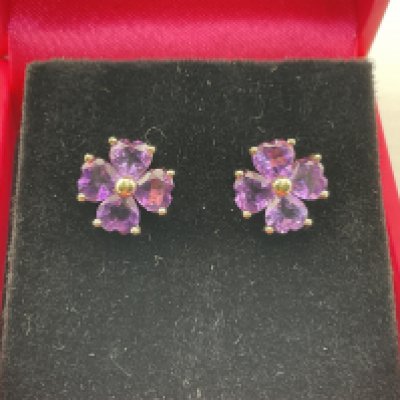 A pair of 9ct gold earrings set with amethyst in the form of a flower. Postage category A.