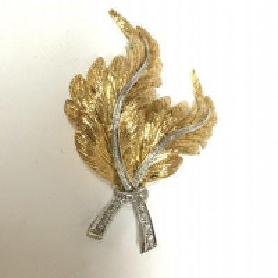 An elaborate 18carat gold brooch with white and yellow gold with small diamonds. Weight 12.8g