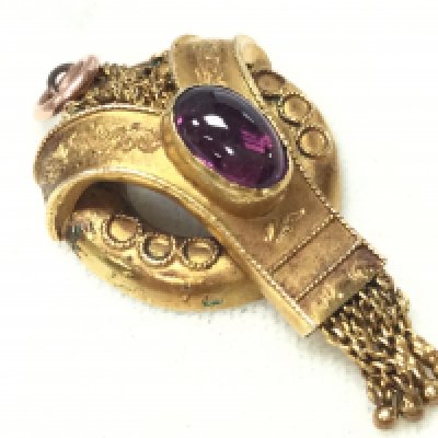 A 15ct gold Etruscan pendant set with a red Cabochon stone. Postage category A