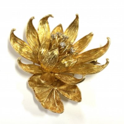A diamond set gold waterlily brooch by Kutchinsky, 6 brilliant cut diamonds set upon the stamens 18ct gold petals, signed, maker's mark and London hallmarks for 1969, 5cm wide. 28.25g (A)