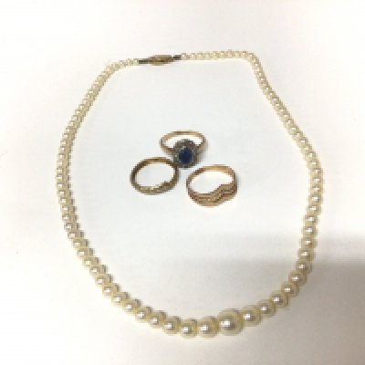 A 9carat gold ring set with a sapphire two other gold rings and a cultured pearl necklace with a 9carat gold clasp.