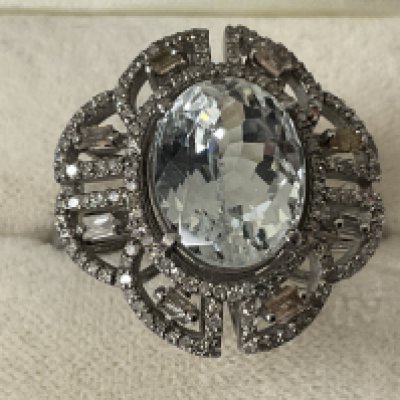 Ornate dress ring in silver, set with an oval aquamarine surrounded by baguette and R/C diamonds in a filigree mount, boxed. Aquamarine 7.60ct. Diamonds 0.69ct. Ring size approx Q/R. Postage category A.