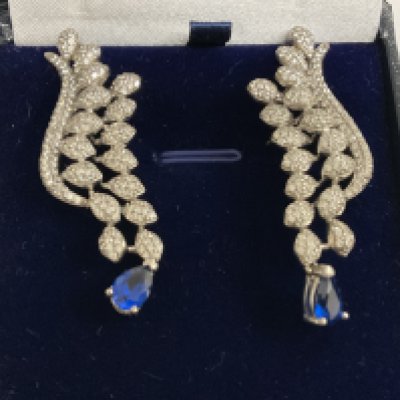 Pair silver fancy long drop earrings set with clusters of white cubic zirconia, and suspended pear shaped blue cubic zirconia, boxed. Postage category A.