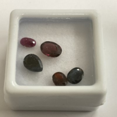 Parcel of loose gemstones, including sapphire, ruby and garnet, boxed. Sapphires 1.47ct. Ruby 0.37ct. Garnet 1.39ct. Postage category A.