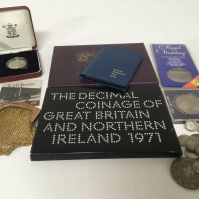 A collection of coins including 3d part silver coins a gold plated purse cased coins.
