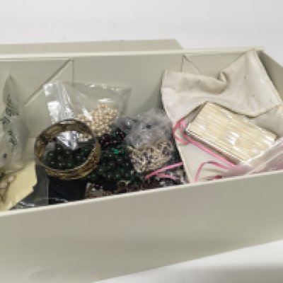 A box containing costume jewellery including a green jade necklace an antique garnet necklace pearl necklaces and other ornaments.
