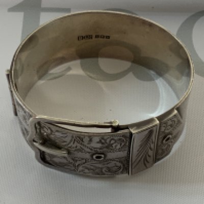 A heavy hallmarked silver buckle design bangle, with silver pill box. (A) 69g.