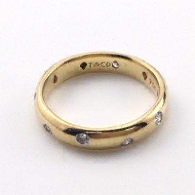 An 18k gold Tiffany and Co wedding ring. Size Q 1/2 and 6.20g. Comes with original inner and outer box.Postage B
