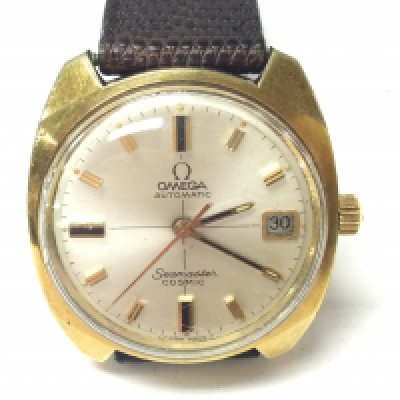 An Omega seamaster cosmic automatic date wrist watch. Gold plated case with baton markers and champagne dial. Brown leather strap with omega buckle and box. Seen running. Postage B