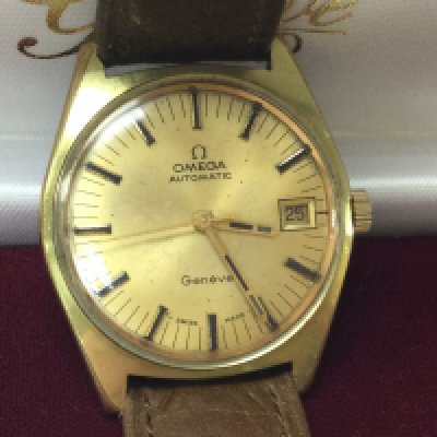 Am Omega Geneve automatic gold plated watch with tan strap and omega buckle. Circa 1971. Comes with box and seen running. Case approx 36mm. 565 cal. Postage B