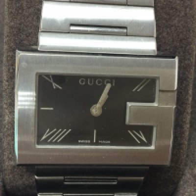 A ladies Gucci stainless steel watch. Black dial with box and papers. Seen running, Postage B