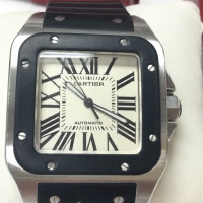 A gents Cartier Santos100 automatic wrist watch. Stainless steel case with black rubber strap. Case is 38mm wide excluding crown. Comes with box and papers. Seen running. Postage B