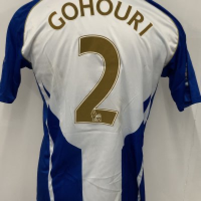 Wigan Athletic 2009 - 2010 Match Worn Football Shirt: Blue and white striped Vandanel 188 Bet short sleeve shirt with Premier League badging to sleeves. Number 2 Gohouri to rear. Worn v Portsmouth. Mud marks.