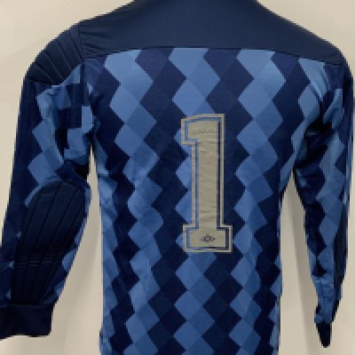 England 1989 Signed Football Shirt: Blue long sleeve Umbro goalkeeper shirt with number 1 to rear. Signed by Peter Shilton and a signed photo of him wearing the shirt is included. Shilton wore this shirt at a photo shoot to promote his record 109th cap. Not match worn. 