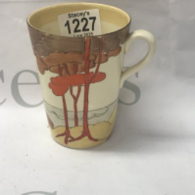 A Clarice Cliff mug decorated with orange trees.