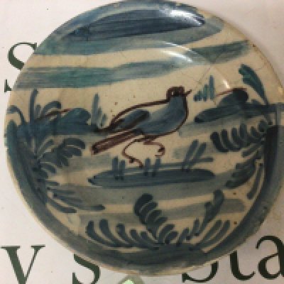 An Antique Continental 18th or early 19th century slip decorated ceramic dish the centre with a nave bird amongst foliage. Some minor damage in keeping with age