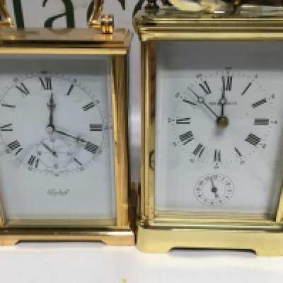 Two gilt carriage clock the dials with Roman numerals and second subsidiary dials one with strike repeat button.