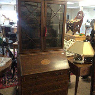 An Edwardian mahogany and satinwood banded bureau bookcase with a shaped pediment above a fall front and four graduating drawers.