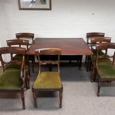 An Early Victorian mahogany drop leaf dinning table and a set of eight mahogany dining chairs with drop in seats including a pair of open are chairs with scrolls. (D)