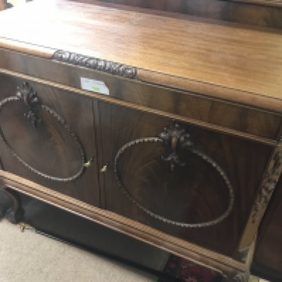 A mahogany side cabinet the raised back above a pair of door on cabriole legs .