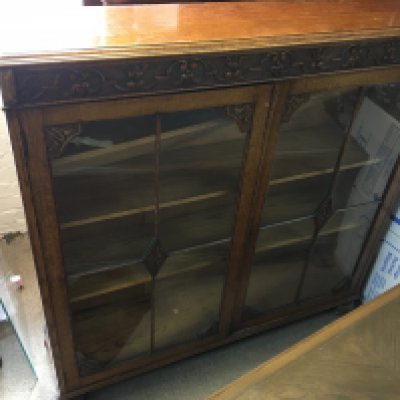 A carved design oak double door cabinet, in need of restoration. Dimensions 122x30x123cm
