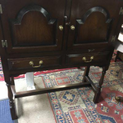 A oak cupboard the two drawers above two single drawers on turned legs .