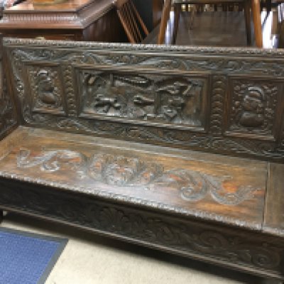 A carved oak hall settle , 155cm wide 95cm tall